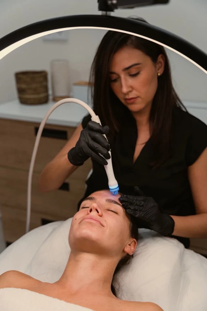 An aesthetic provider performing a facial treatment
